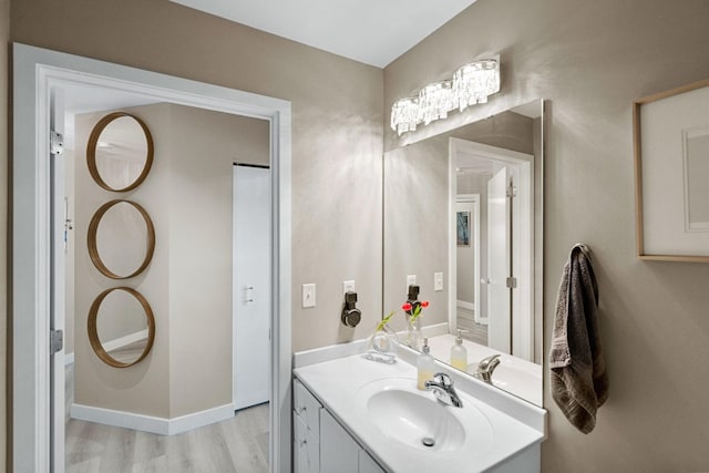 bathroom with vanity, wood finished floors, and baseboards