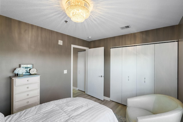 bedroom featuring light wood-style flooring, a closet, and a chandelier