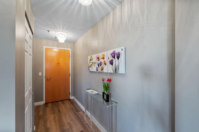 doorway with wood finished floors and baseboards