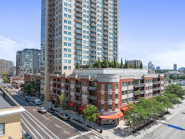view of apartment building / complex featuring a city view and uncovered parking