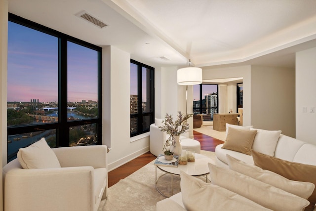 living area featuring wood finished floors, a view of city, and baseboards