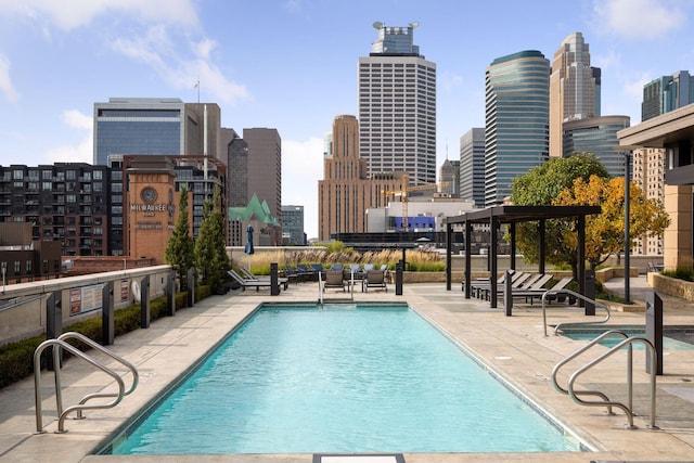 community pool with a view of skyline and a patio