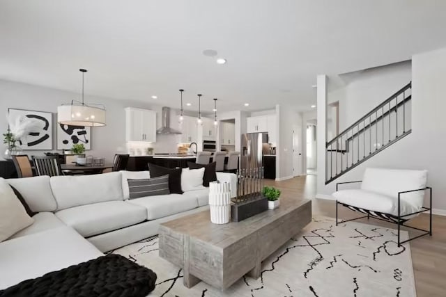 living room featuring stairway, light wood-type flooring, recessed lighting, and baseboards