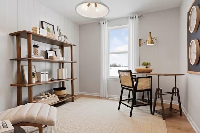 living area with light wood-type flooring and baseboards