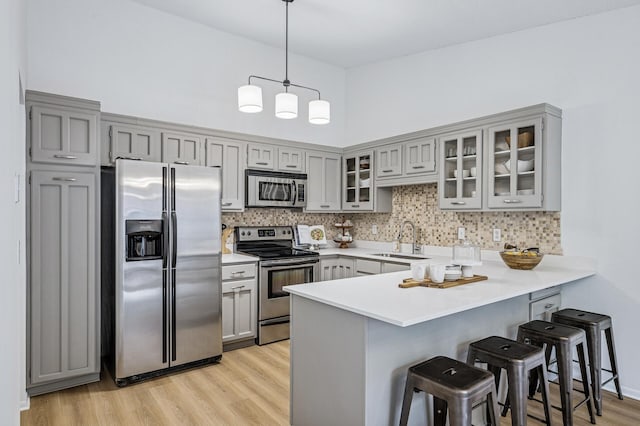 135 Eagle Lake Dr, Maple Grove, MN 55369 - kitchen featuring stainless steel appliances, gray cabinets, a sink, a peninsula, and a kitchen breakfast bar