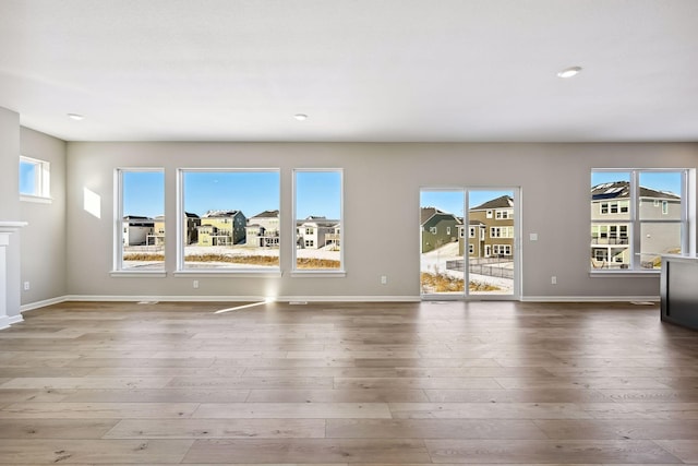 7197 Large Ave NE, Otsego, MN 55301 - unfurnished living room featuring healthy amount of natural light, wood finished floors, baseboards, and recessed lighting