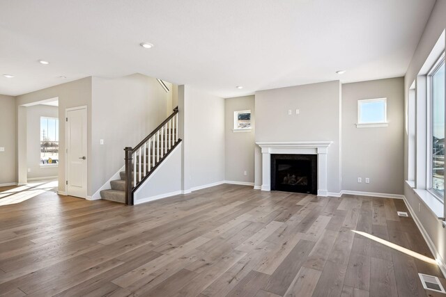 7197 Large Ave NE, Otsego, MN 55301 - unfurnished living room with wood finished floors, stairway, baseboards, and recessed lighting