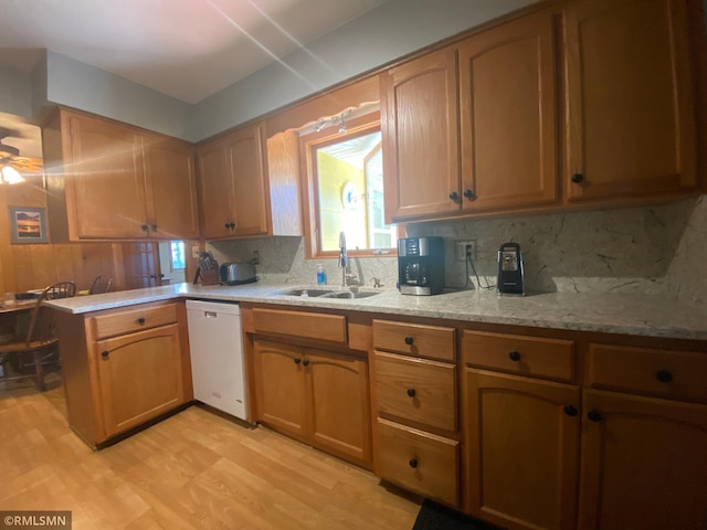 2828 Matilda St, Roseville, MN 55113 - kitchen featuring a sink, dishwasher, a peninsula, decorative backsplash, and light wood-type flooring