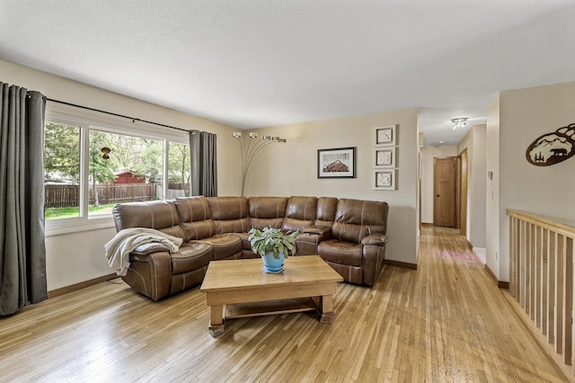 living area with baseboards and light wood-style flooring