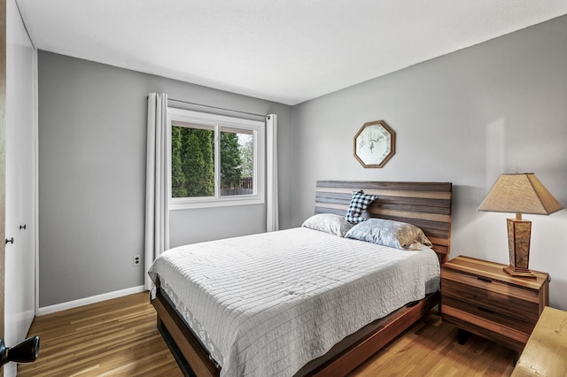 bedroom featuring wood finished floors and baseboards