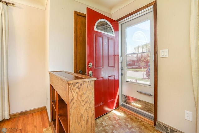 foyer entrance with wood finished floors and baseboards