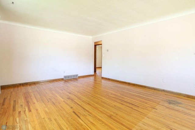 empty room with light wood finished floors and baseboards