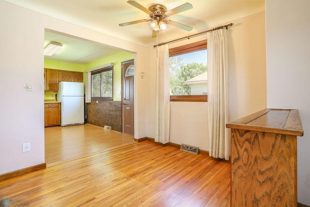 entryway with light wood-type flooring, ceiling fan, and baseboards