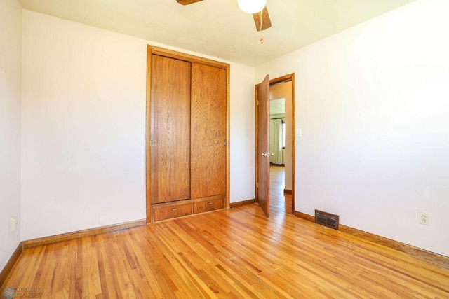 unfurnished bedroom featuring light wood finished floors, baseboards, a closet, and ceiling fan