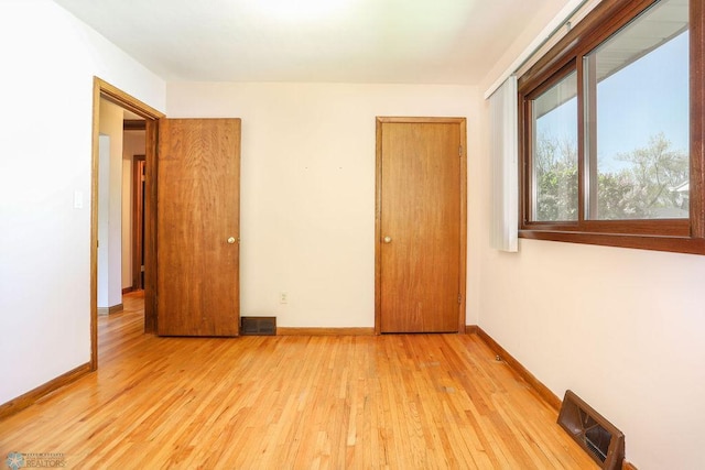 unfurnished bedroom featuring wood finished floors and baseboards