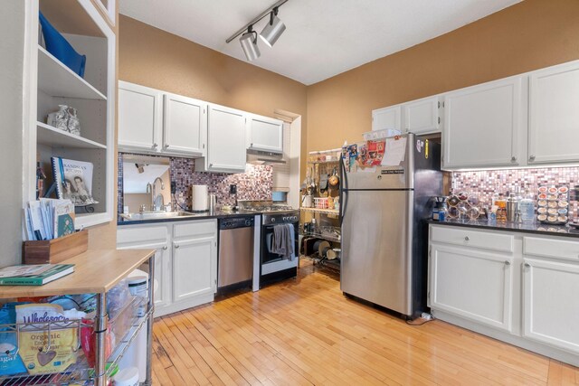 kitchen featuring stainless steel appliances, a sink, under cabinet range hood, backsplash, and open shelves