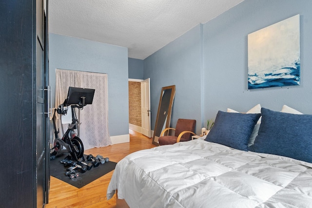 bedroom with wood finished floors and a textured ceiling