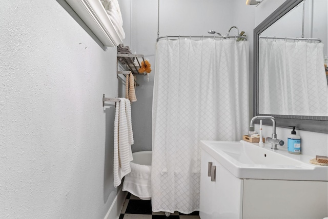 full bath with vanity, a textured wall, and a shower with shower curtain