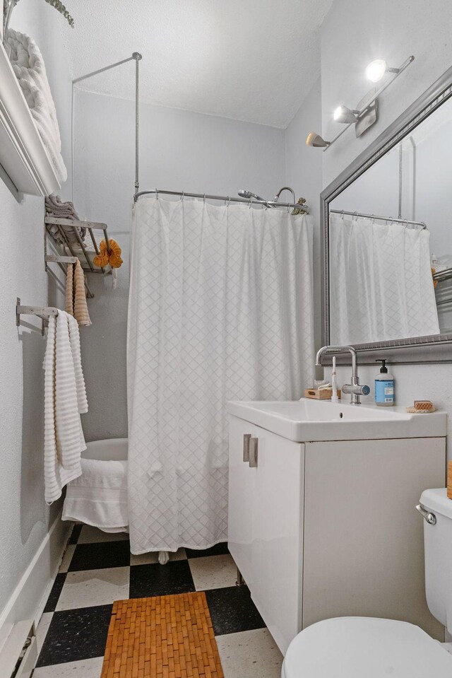 full bathroom featuring tile patterned floors, toilet, vanity, and curtained shower