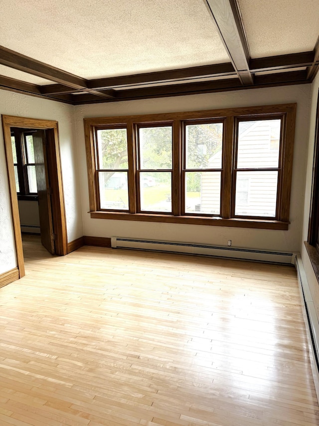 455 3rd St SE, Cokato, MN 55321 - empty room featuring beamed ceiling, coffered ceiling, baseboard heating, light wood-style flooring, and a textured ceiling