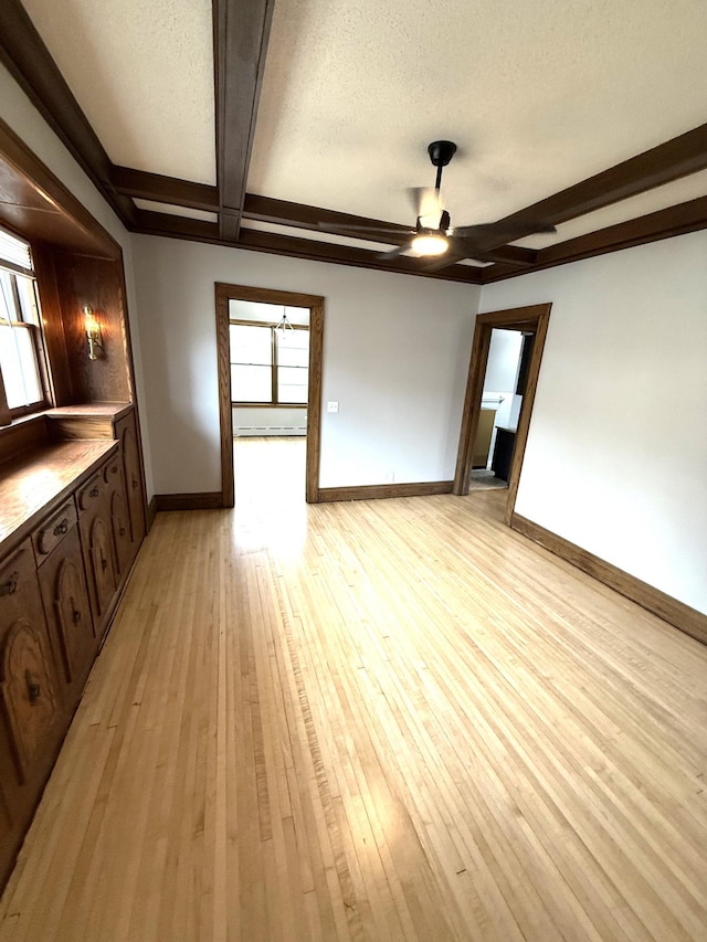 455 3rd St SE, Cokato, MN 55321 - unfurnished living room with beamed ceiling, a ceiling fan, light wood finished floors, and a textured ceiling