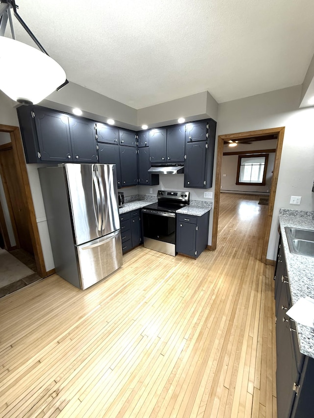 455 3rd St SE, Cokato, MN 55321 - kitchen with stainless steel appliances, under cabinet range hood, light wood-type flooring, a textured ceiling, and light stone countertops