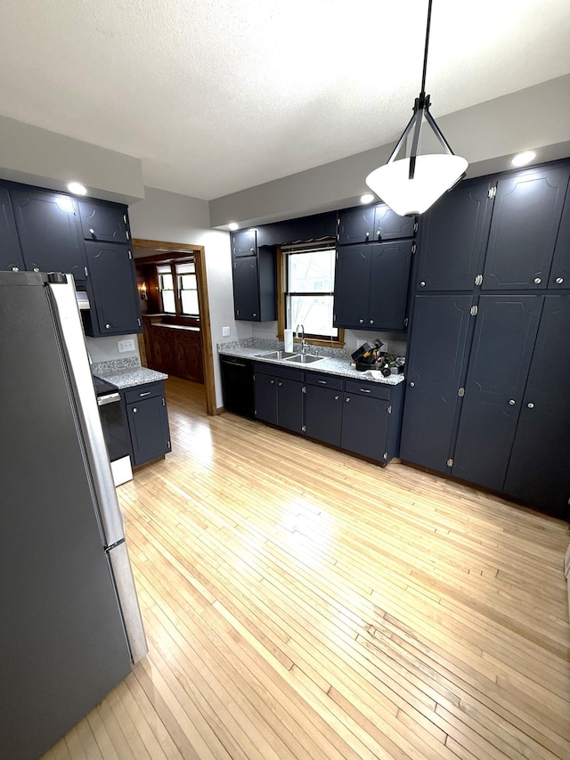 455 3rd St SE, Cokato, MN 55321 - kitchen featuring freestanding refrigerator, light countertops, light wood-type flooring, decorative light fixtures, and stove
