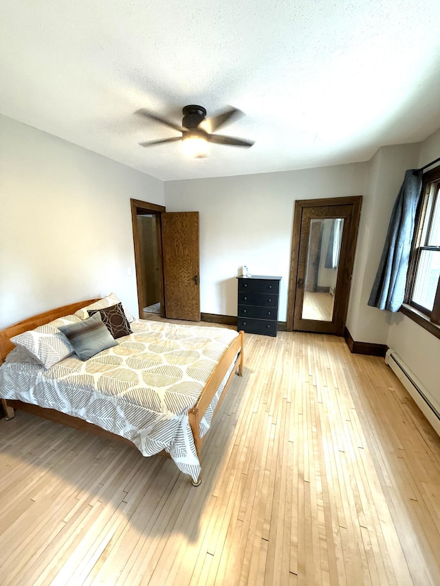455 3rd St SE, Cokato, MN 55321 - bedroom featuring light wood-type flooring, a baseboard radiator, and a ceiling fan