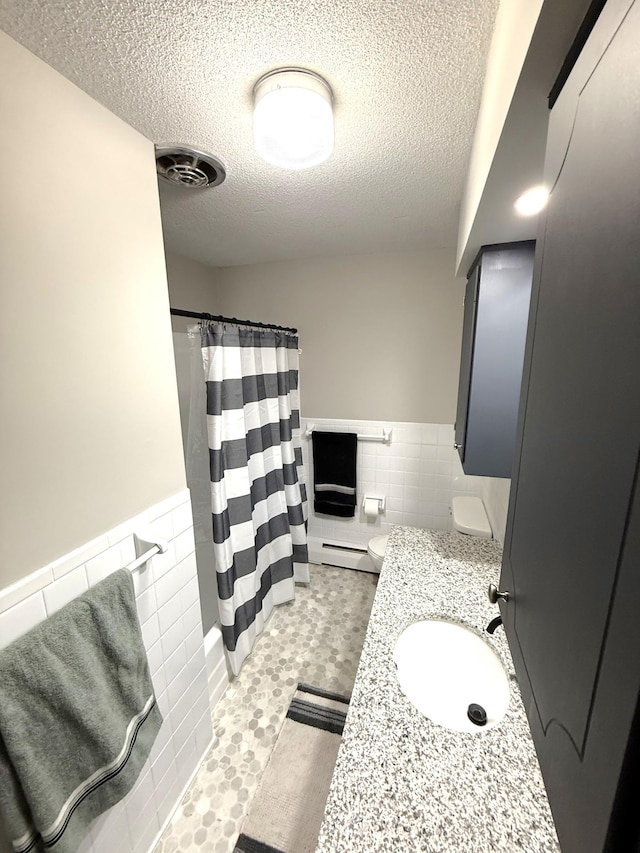 455 3rd St SE, Cokato, MN 55321 - bathroom with tile walls, a baseboard heating unit, a textured ceiling, a wainscoted wall, and curtained shower