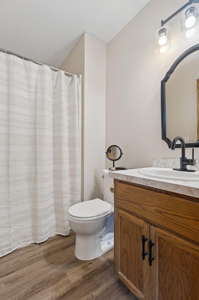 1284 Otter Ridge Rd, White Bear Twp, MN 55110 - bathroom with wood finished floors, vanity, toilet, and a textured ceiling