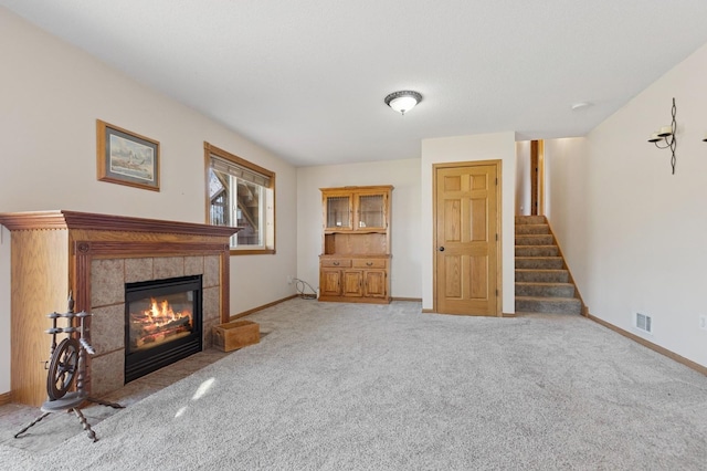 1284 Otter Ridge Rd, White Bear Twp, MN 55110 - unfurnished living room with baseboards, stairway, a tile fireplace, and carpet floors