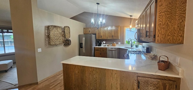 1284 Otter Ridge Rd, White Bear Twp, MN 55110 - kitchen with stainless steel appliances, brown cabinets, a sink, light countertops, and a peninsula
