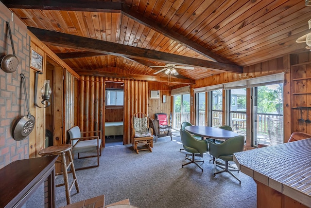 interior space featuring carpet, ceiling fan, and wood walls