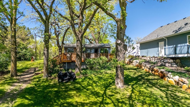 view of green lawn featuring a wooden deck