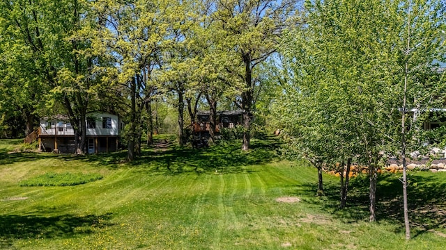 view of green lawn with a deck