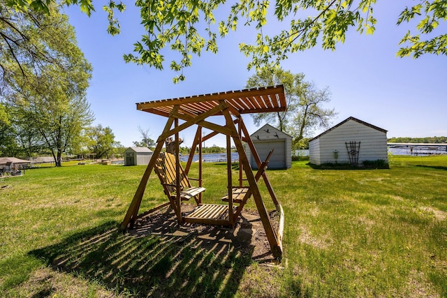 view of grassy yard featuring an outdoor structure and a water view