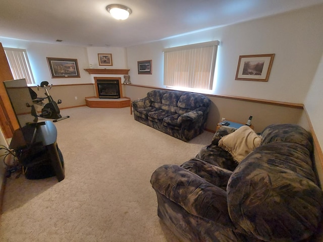 living area with carpet floors and a glass covered fireplace