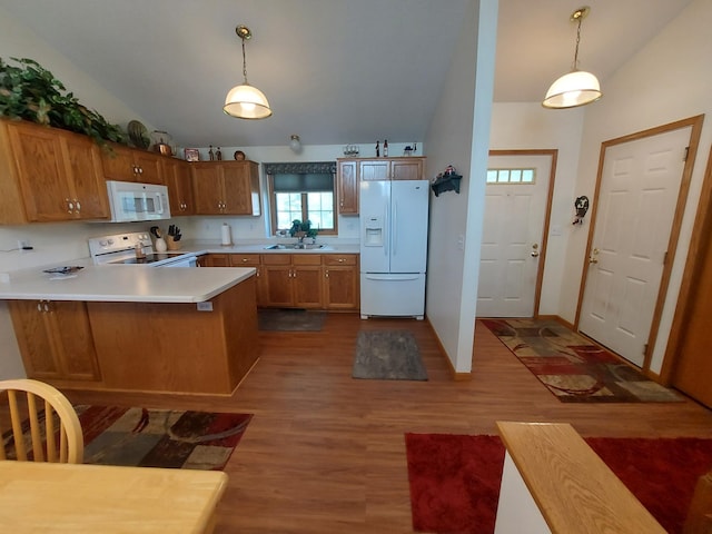 kitchen with white appliances, vaulted ceiling, a peninsula, dark wood-type flooring, and a sink