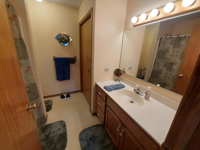 full bath featuring vanity, a shower with shower curtain, and baseboards