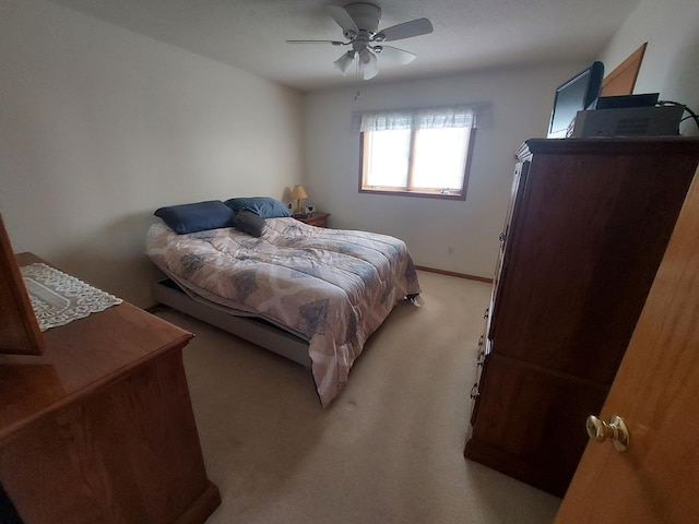 bedroom with light colored carpet, ceiling fan, and baseboards