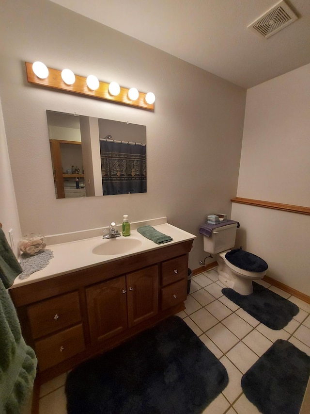 full bathroom with tile patterned floors, vanity, toilet, and baseboards