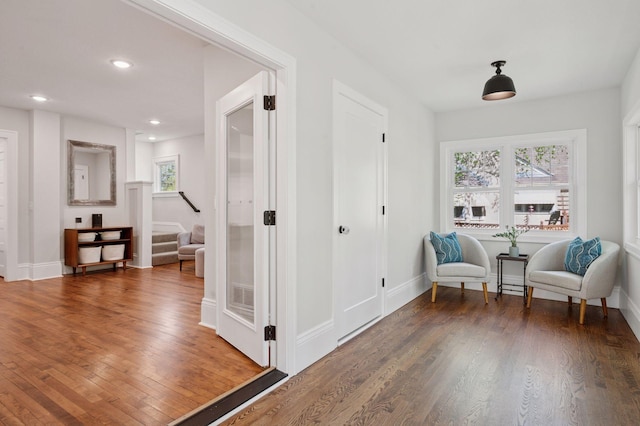 living area with wood finished floors, stairs, baseboards, and recessed lighting