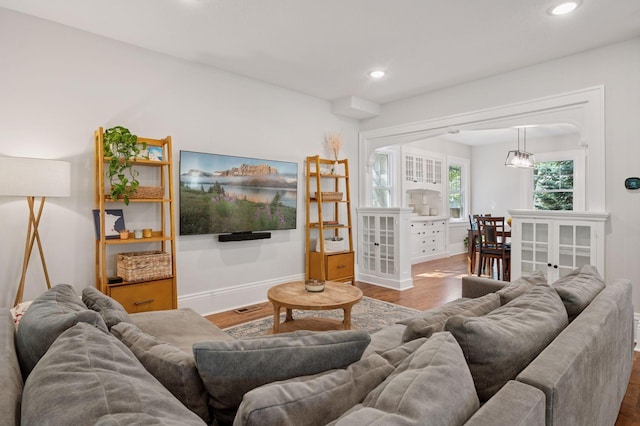 living area with wood finished floors, recessed lighting, and baseboards