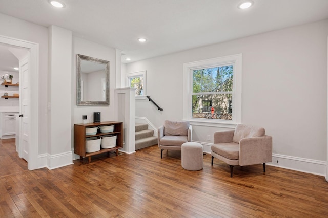 living area with wood-type flooring, stairway, baseboards, and recessed lighting