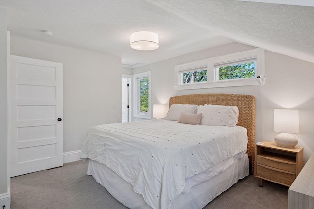 carpeted bedroom featuring a textured ceiling and baseboards