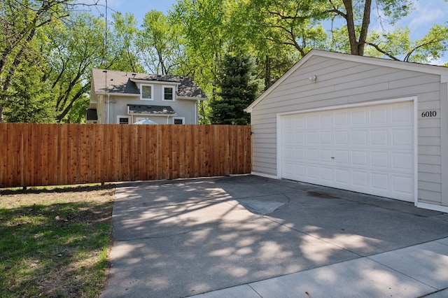 detached garage featuring fence