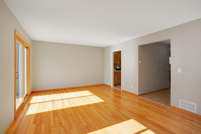 empty room with light wood finished floors and baseboards