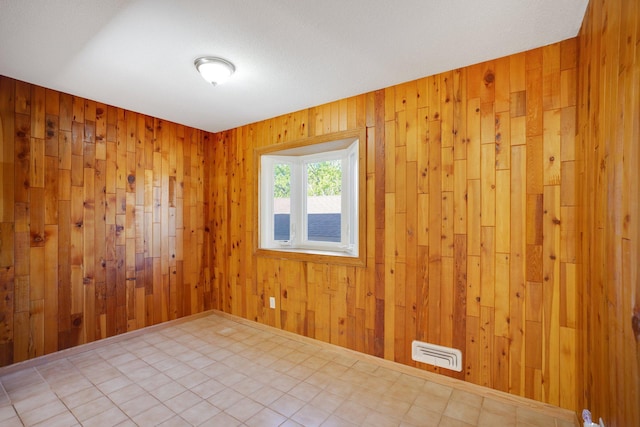 unfurnished room featuring wood walls