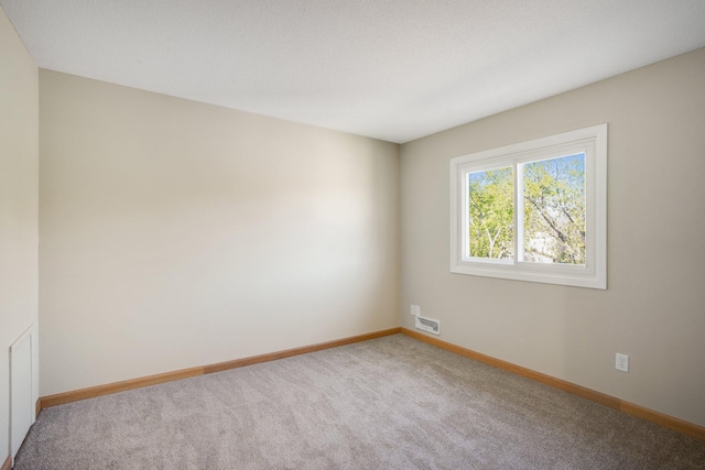 empty room featuring carpet floors and baseboards