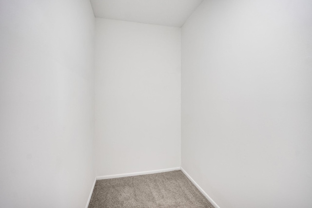 empty room featuring light carpet and baseboards